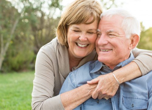 Woman hugging old man following skin cancer reconstruction
