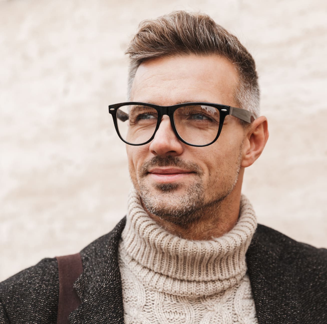 Stylish older man wearing glasses and a turtleneck sweater under a blazer